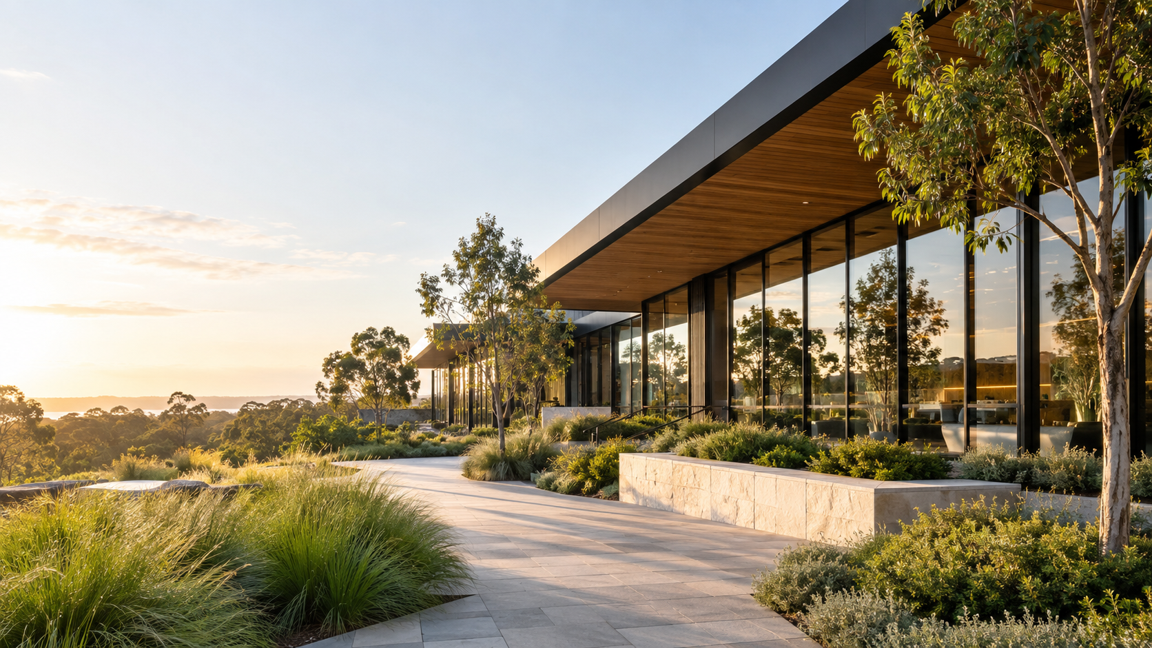 Illustrative contemporary commercial building with warm interior lighting and landscaped gardens